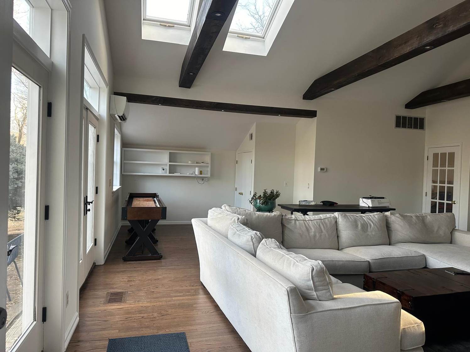 Bright finished living room with skylights and exposed wood beams, painted by Roy Painting Services in Chester County, PA